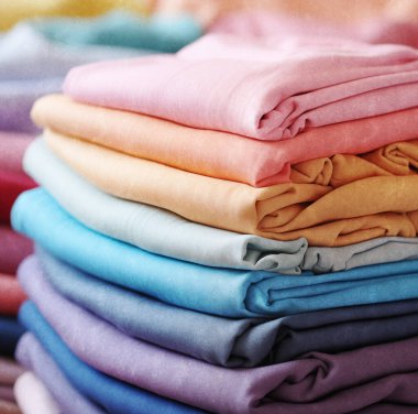 Gökkuşağı renginde bir moda elbisesi. Farklı renkli giysilerin arkaplanı, soyut kumaş örnekleri.