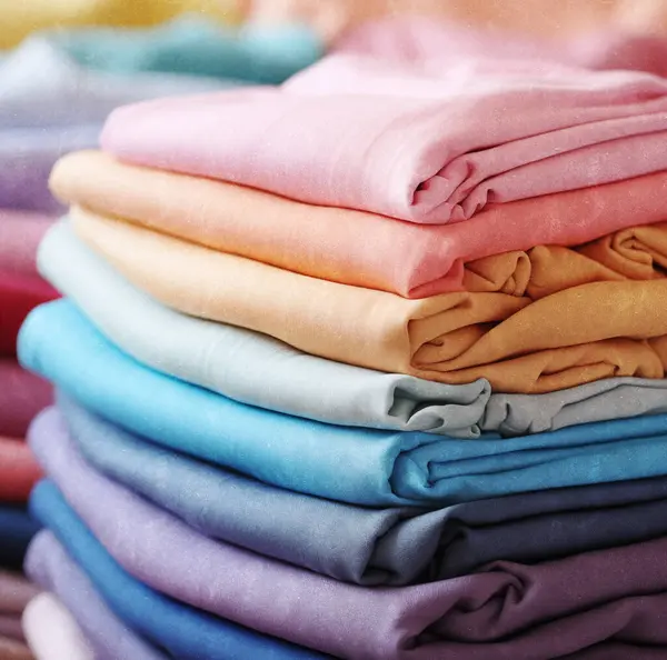 Gökkuşağı renginde bir moda elbisesi. Farklı renkli giysilerin arkaplanı, soyut kumaş örnekleri.