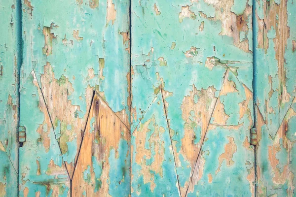 Wooden facade with peeling paint in cyan colors for an abstract background