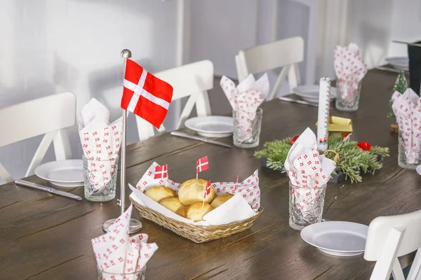 传统的丹麦式生日餐桌 上面有彩旗和烤箱里的新鲜面包 图库照片