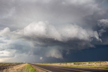 Düzlüklerdeki boş bir otobanın üzerinden şiddetli bir fırtına geçiyor..