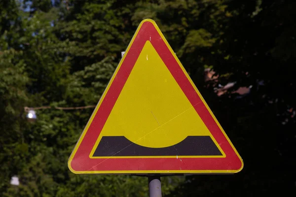 A triangular road sign of work in progress indicating the presence of bumps.