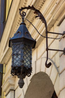 Siyah metalden yapılmış eski moda sokak lambası. Eski bir evin gri cephesi. Lviv, Ukrayna.