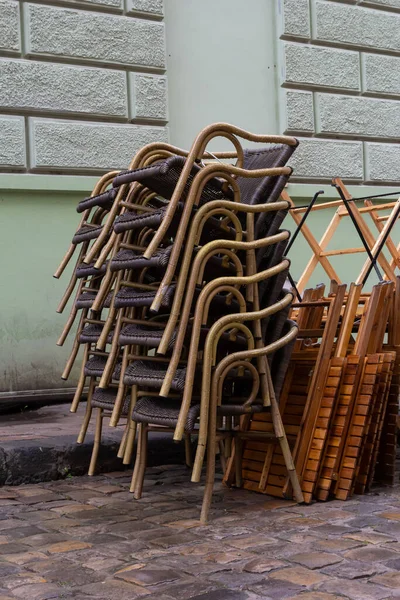 stock image chairs folded. stainless steel polished tables in front of a cafe wet from rain and dew. the season of outdoor terraces ends.