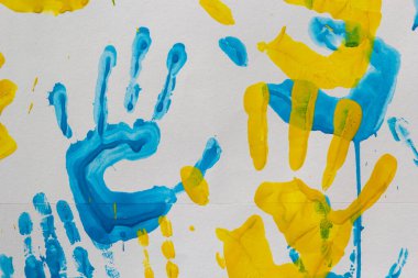 bright prints of children's hands from paint on the wall, background, texture, horizontal format.