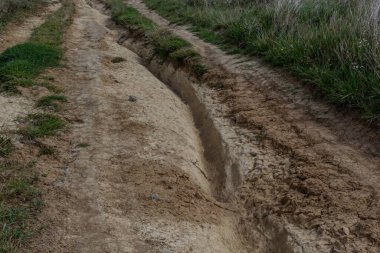 Yıkanmış toprak yol ve baharda akan su izleri. Off-road.