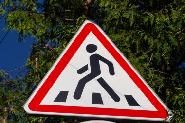 Yol işareti Çocuklar, gölgedeki bir ağaca karşı.