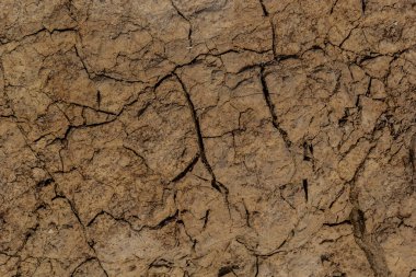 Zemin, kuraklık ve ölüm kavramına sahip arka plan veya grafik tasarımı için üst görünümde çatlaklar var..