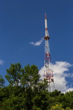 Telekomünikasyon kulesi mavi gökyüzünde antenli cep telefonu için. Sözleşmeli cep telefonlarının dağıtım işlevi.