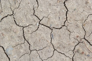 Zemin, kuraklık ve ölüm kavramına sahip arka plan veya grafik tasarımı için üst görünümde çatlaklar var..