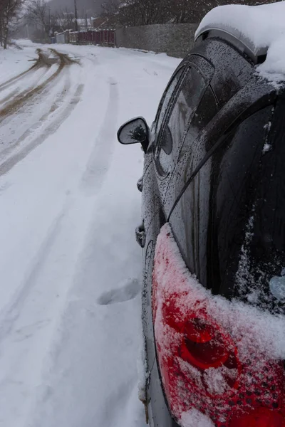 冬の吹雪の後雪に覆われた車の後部テールライト — ストック写真
