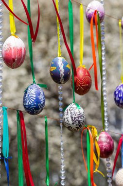 Boyalı yumurtalar Paskalya ağacının dallarına asılır. Odak noktası, çocuklar tarafından elle boyanmış sarı bir yumurta. Yüksek kalite fotoğraf
