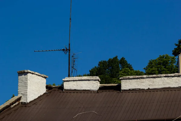 天に対する戸建住宅や煙突の金属屋根 金属屋根瓦 — ストック写真