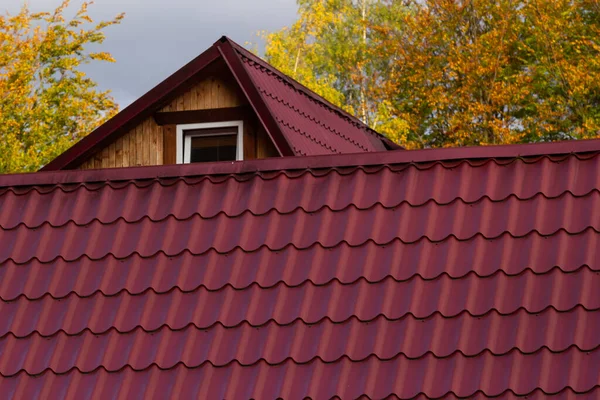 新しい茶色の金属タイルの屋根と雨のガター付きの家 金属ゲーターシステム ゲーターおよび排水管外観 — ストック写真