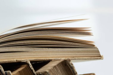 Beyaz arka plan üzerine açık bir kitabı olan eski kitaplar yığını. Kitapçı, bilgi yayını, edebiyat. Kitapçı kitapçısı..