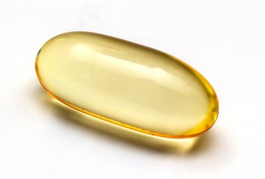 Açık arkaplanda balık yağı kapsülleri Omega 3. Balık yağının saydam sarı kapsülleri.