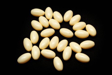 Beyaz kapsüller, siyah arka planda haplar. Tıp, sağlık hizmeti konsepti. Eczacılık ilaçlarının aralığı.