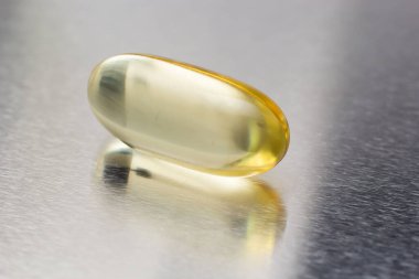 Açık arkaplanda balık yağı kapsülleri Omega 3. Balık yağının saydam sarı kapsülleri.