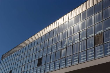 Promosyon içeriği için gökyüzü arka planında cam penceresi olan modern bir gökdelen binasının alt manzarası. Yeni perspektif tasarımlı çağdaş iş merkezi.