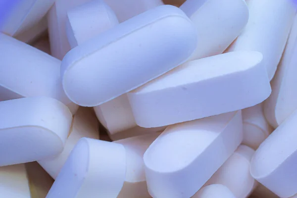 Pills drugs tablets vitamins macro image close up white. Medicine, healthcare concept. Range of pharmaceutical drugs.