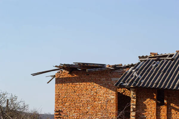 Destroyed roof of brick house. Destroyed house after a storm or as a result of shelling.