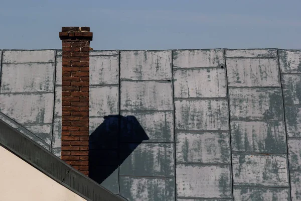 Metal roof of a detached house and chimney against the sky, metal roof tiles, gutters.