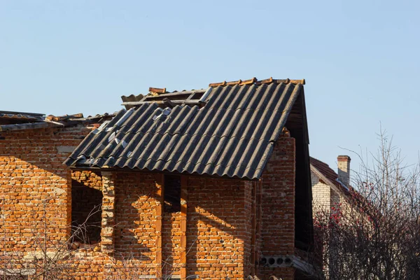 Destroyed roof of brick house. Destroyed house after a storm or as a result of shelling.