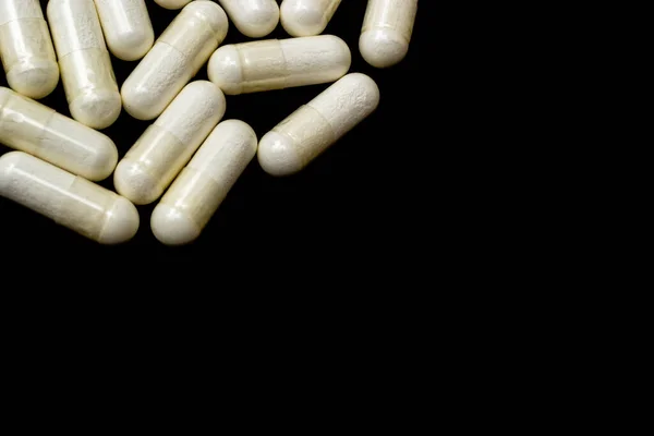 白色胶囊 药丸在黑色背景与文字的地方 医疗保健概念 药物的范围 — 图库照片