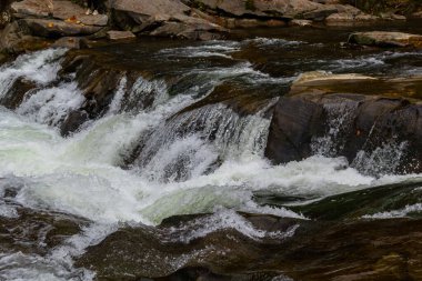Kayaların üzerinden akan su akıntısı. Görüntüyü yaklaştır..