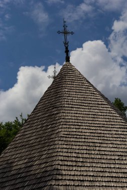 Ukrayna 'da mavi gökyüzüne karşı eski ahşap kilise, haçlı ahşap çatı.