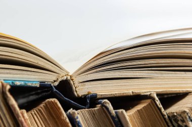 Beyaz arka plan üzerine açık bir kitabı olan eski kitaplar yığını. Kitapçı, bilgi yayını, edebiyat. Kitapçı kitapçısı..