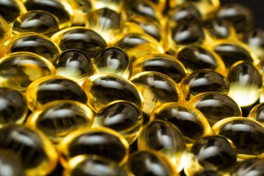 Omega 3 jel kapsülünü yansıtıcı siyah arka planda kapat.