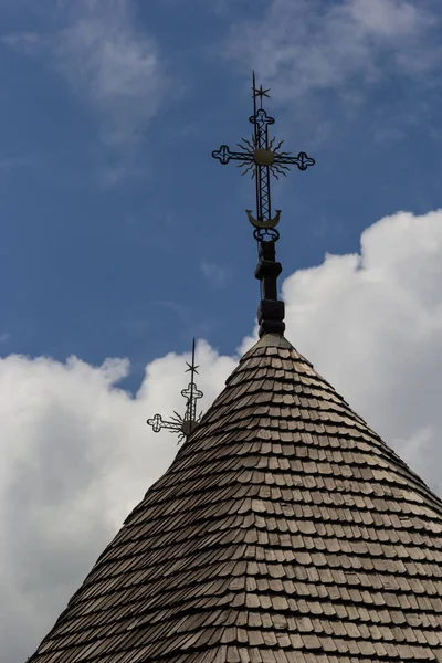 ウクライナの青い空に対する古い木造教会十字架と木製の屋根 — ストック写真
