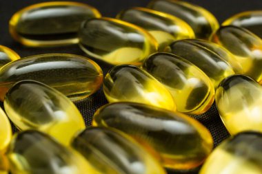 Omega 3 jel kapsülünü yansıtıcı siyah arka planda kapat.