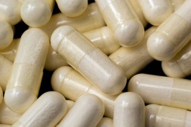 Beyaz kapsüller, siyah arka planda haplar. Tıp, sağlık hizmeti konsepti. Eczacılık ilaçlarının aralığı.