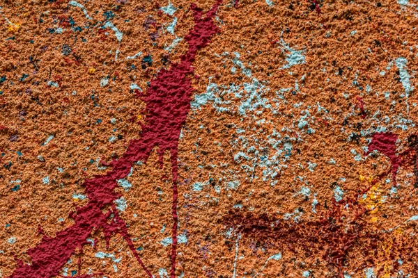 White plastered wall splattered with red paint. Paint splashes on the wall. Painted plaster wall. Abstract background. Painted plaster texture.