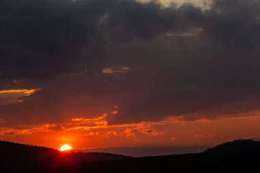 Ufuk manzarası ve dramatik alacakaranlık gökyüzü ve günbatımı arka planı. Doğal gökyüzü arkaplan dokusu, güzel bir renk. Kara bulutlar, büyük fırtına ve yağmur. Hava ve doğa kavramı.