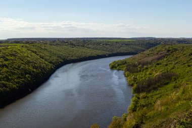 Ağaçlarla kaplı yeşil kıyılarda bir nehir..