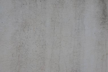 Arnavutluk 'un kentsel bir bölgesinde bulunan ve kırsal özelliklerini vurgulayan görünen, eski beton bir duvarın ayrıntılı dokusu.