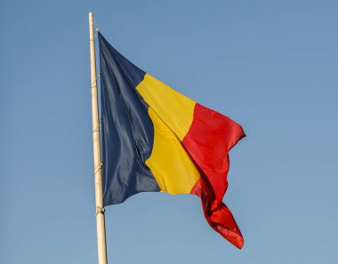 Romanya 'nın ulusal bayrağı Bükreş' teki güneşli mavi gökyüzünün altında dalgalanarak ülkenin mavi, sarı ve kırmızı renklerini gözler önüne seriyor.