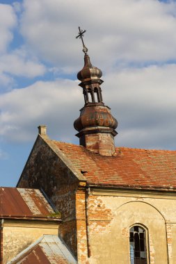 Kilise, tüylü bulutlarla çevrili eşsiz bir kuleye ve yıpranmış tuğla cephesine sahip. Detaylı mimaride kültür mirası ve tarihi sergileniyor.