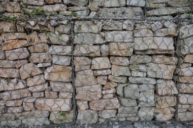 Arnavutluk 'un dağlık bir bölgesinde, taşlarla dolu Gabion kafesleri, etkin bir erozyon kontrolü ve peyzaj desteğinin altını çizen sağlam bir kaya duvarı oluşturuyor..