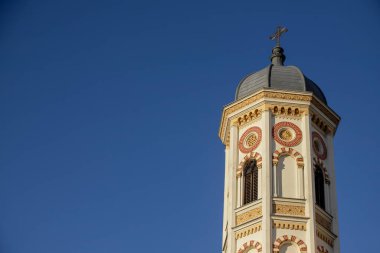 Romanya 'nın Bükreş kentinde belirgin bir şekilde yükselen çan kulesi, süslü tasarımlar ve açık mavi gökyüzüne karşı güzel bir kontrastla kentin zengin tarihini vurguluyor.
