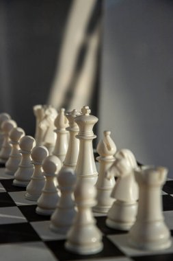 Bükreş 'in üzerine alacakaranlık çökerken, entrika ile tasarlanmış beyaz satranç taşları siyah beyaz bir satranç tahtasının üzerinde duruyor..
