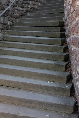 Sert taş basamaklar, kaba yontulmuş duvarlar arasında yükselir. Doğal ışık tarafından aydınlatılan yıpranmış bir yolda tarih ve yaş duygusu uyandırır..