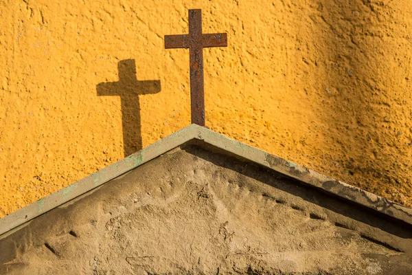 Kruis Een Grafsteen Bij Een Gele Muur — Stockfoto