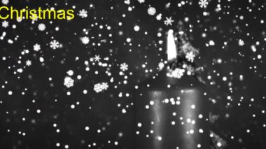 Yanan mum, karlı köknar ağacı ve döner tablaya düşen kar 