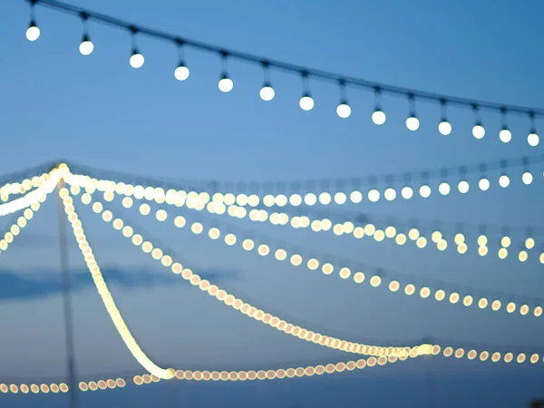 Party lights at outdoor wedding. string lights. defocused bokeh lights in blur. blurred background.