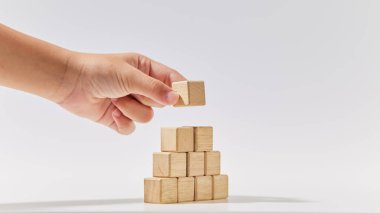 Beyaz arka planda sembol ya da logo, iş büyümesi ve yönetim konsepti oluşturmak için tahta küpleri piramit şeklinde düzenle