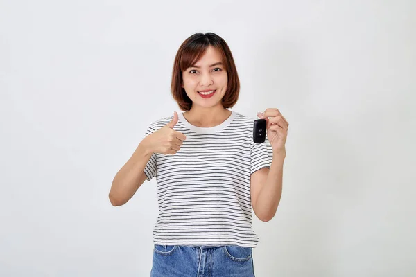 stock image Beautiful young business Asian woman with brunette short hair wearing a t-shirt and jeans with a car key on white isolated background